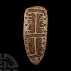 Papua New Guinea Shield Mid 20th century A.D. or earlier. An oviform wooden plaque displaying a geometric scheme in relief with dark staining to the b...