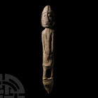 Inuit Large Carved Bone Figure Circa 1900 A.D. A bone stylised figure carved in the half-round standing on a sub-conical base, the figure holding his ...