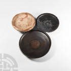 Greek Terracotta Bowl Group Circa 5th-3rd century B.C. A trio of terracotta vessels: a bowl with carinated body and inverted rim; a shallow, black-gla...