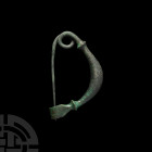 Large Greek Bow Brooch 8th-6th century B.C. A bronze brooch with a round-section, leech-shaped body with herringbone decoration, biconvex collars, int...