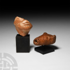 Hellenistic Terracotta Group 3rd-1st century B.C. A group of two terracotta figure fragments comprising: the lower portion of a human face, encompassi...