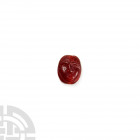 Etruscan Scaraboid Bead with Bust 6th-5th century B.C. A carved red carnelian scaraboid bead decorated with a face in relief, semi-naturalistic detail...