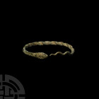 Roman Snake Bracelet Circa 1st century A.D. A penannular twisted wire bracelet in the form of a coiled snake, one terminal formed as the serpent's tai...