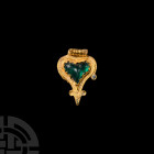 Byzantine Gold Pendant with Green Gemstone 13th-15th century A.D. A gold heart-shaped pendant with filigree ornament to the body, set with a green gla...
