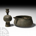 Western Asiatic Vessel Group Circa 14th century A.D. A group of two copper-alloy vessels comprising: a candlestick holder with bulbous body, deep foot...