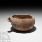 Terracotta Bowl with Spout Bronze Age, 2nd millennium B.C. A terracotta bowl with rounded, oval-shaped body and integral flared spout. 370 grams, 17 c...