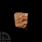 Proto Cuneiform Tablet Fragment Circa 4th millennium B.C. A proto-cuneiform ceramic tablet fragment bearing impressed forms to one face. 6.5 grams, 25...