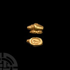 Gold Shell Seal Bead 1st millennium A.D. A gold seal in the form of a sea shell on an oval-shaped base, bearing incuse enigmatic design; pierced for s...