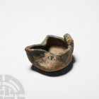 Western Asiatic Green-Glazed Oil Lamp 13th-15th century A.D. A green-glazed ceramic oil lamp of trefoil form, with applied handle and shallow circular...