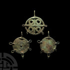 Amlash Pendant Group 2nd millennium B.C. A trio of discoid pendants with suspension loops, two with spiralling plaques and pellets with loops to the p...