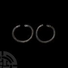 Western Asiatic Animal-Headed Bracelet Pair 1st millennium B.C. A matching pair of copper-alloy bracelets, each with a round-section hoop and beast he...