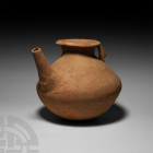 Luristan Spouted Vessel 2nd-1st millennium B.C. A large ceramic pouring vessel with bulbous body and trumpet-shaped mouth, keeled strap handle to the ...