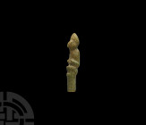 Western Asiatic Bone Pin Finial 1st millennium B.C. A carved bone dress pin finial of a seated figure with ring-and-dot motifs to the reverse, hands d...