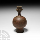 Western Asiatic Candlestick Holder 19th century A.D. or earlier. A bulbous copper-alloy candlestick holder with a series of decorative studs to the ne...