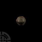 Western Asiatic Decorated Bronze Bead Circa 1st millennium B.C. A biconical bronze bead decorated with shallow vertical ribs around the exterior; larg...