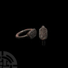 Neo-Babylonian Silver Ring with King and Offerant 7th-6th century B.C. A silver ring with round-section hoop, oblong bezel bearing incuse figural scen...