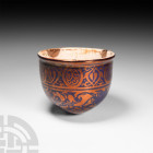 Western Asiatic Blue-Glazed Vessel Late 19th century A.D. A carinated ceramic vessel with everted rim, white glaze to interior, bronze-coloured floral...