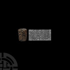 Mesopotamian Cylinder Seal Mid 2nd millennium B.C. A stone cylinder seal with a deeply-cut herringbone frieze, some lines overlapping; accompanied by ...