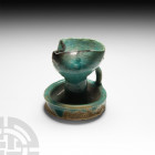 Western Asiatic Glazed Pinched Oil Lamp 12th-14th century A.D. A glazed turquoise-coloured oil lamp with a pinched bowl and dish-style drip tray, slen...