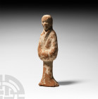 Chinese Tang Attendant Figure Tang Dynasty, 618-907 A.D. A ceramic attendant figure standing in floor-length courtly dress, hands held within volumino...