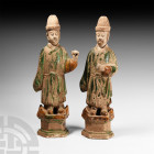 Chinese Ming Retainer Pair Ming Dynasty, 1368-1644 A.D. A pair of glazed ceramic figurines, each a standing retainer in ankle-length robe on a hollow-...