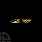 Medieval Gilt Openwork Ring Circa 15th century A.D. A silver-gilt finger ring composed of a D-section hoop and expanded openwork bezel with two shallo...