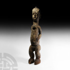 Large West African Standing Wooden Figure 19th-20th century A.D. A large carved wooden figure of a standing nude male with crested hairstyle and shell...