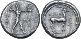 Bruttium, Kaulonia AR Stater. Circa 475-425 BC. Nude Apollo walking to right, holding laurel branch in upright right hand, small daimon running to rig...