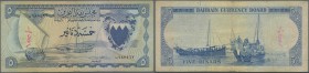 Bahrain: 5 Dinars L.1964 P. 5 in used condition with small ink writing at left, folds and creases, light stain in paper, several pinholes, no tears, s...