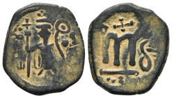 Islamic, Arab-Byzantine, c. 660s-680s. Æ Fals (25mm, 7.10g, 6h), Emperor standing facing, holding long cross and globus cruciger. R/ Cursive M; cross ...