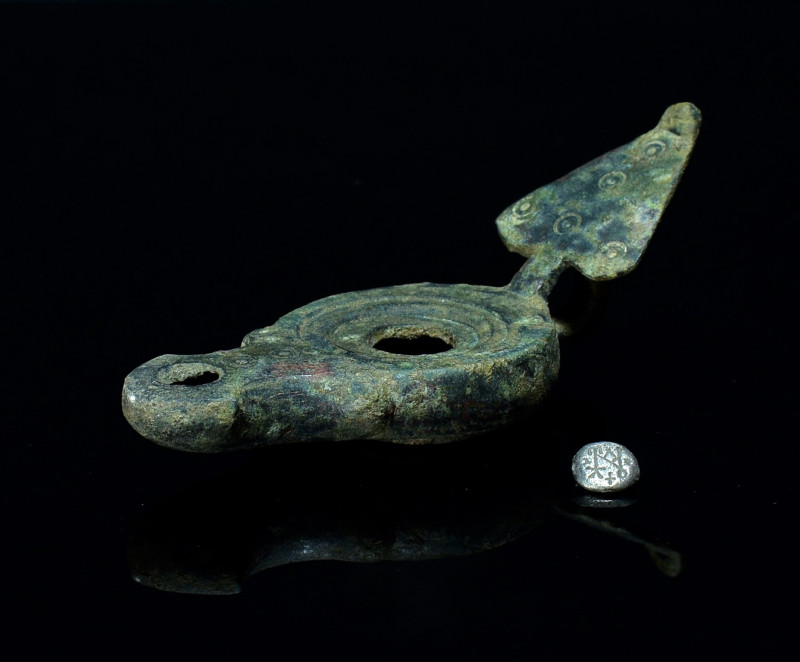 Roman Bronze Oil Lamp. 3rd-4th century AD. A bronze oil lamp with rounded body a...