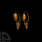 Large Roman Gold Shield Earring Pair
Circa 2nd century A.D. A matching pair of gold earrings, each composed of a tapering hoop with plait-effect lowe...