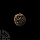 OLD BABYLONIAN SCRIBAL SCHOOL CUNEIFORM TABLET
EARLY 2ND MILLENNIUM B.C. A discoid ceramic tablet with one domed face, bearing cuneiform scribal text...