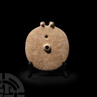 Western Asiatic Twin-Headed Disc Idol
3rd-mid 2nd millennium B.C. A carved limestone disc with trumpet-shaped hub to the centre and perforation above...