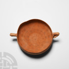 Nabataean Twin-Handled Cup
3rd-1st century B.C. A ceramic vessel with rounded base and carinated shoulder, thin rim with two moulded loop handles. 11...