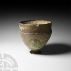 Western Asiatic Tinned Bronze Footed Cup
Mid 1st millennium B.C. A high-tinned bronze cup with raised bands to the shoulder and lip, and a splayed fo...