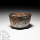 Western Asiatic Rimmed Silver Bowl
Late 1st millennium B.C. A silver bowl with a deep channelled rim and a rounded base. 875 grams, 16.5 cm wide (6 1...