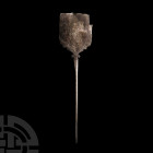 Urartu Silver Pin with Figure
9th-6th century B.C. A silver pin composed of a tapering stem and roughly rectangular head with scalloped and angled lo...