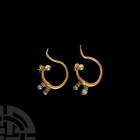 Western Asiatic Gold and Pearl Earrings
Early 1st millennium A.D. A matched pair of gold earrings, each a round-section penannular scroll with looped...