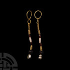 Western Asiatic Gold Bead Drop Earrings
1st millennium B.C. A matching pair of gold drop earrings, each composed of a slender penannular hoop with lo...