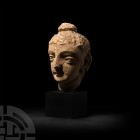 Gandharan Stucco Buddha Head
Circa 3rd-5th century A.D. A stucco Buddha head modelled in the half-round, hair pulled around the ushnisha, slender arc...