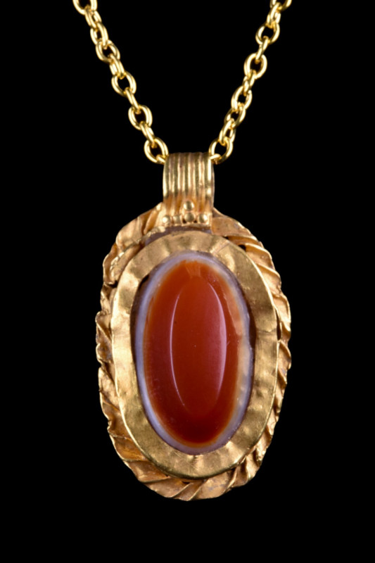 ROMAN GOLD AND CARNELIAN PENDANT
Ca. 100-300 AD. A gold ovoid pendant plaque, w...