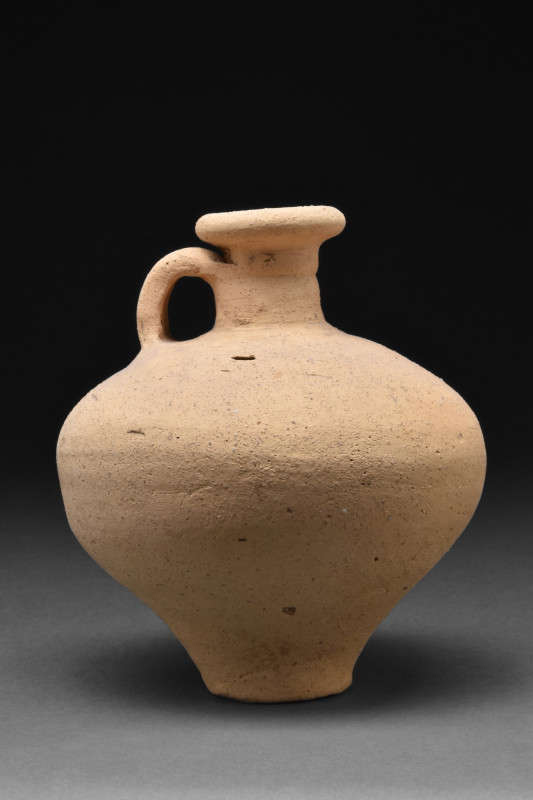 ROMAN TERRACOTTA JUG WITH HANDLE
Ca. 1-300 AD. A pottery vessel in the form of ...