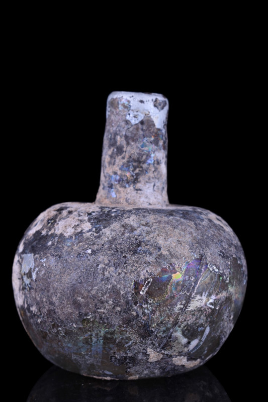 ANCIENT ROMAN GLASS FLASK
Ca. 100-300 AD. A glass flask with a tubular neck and...