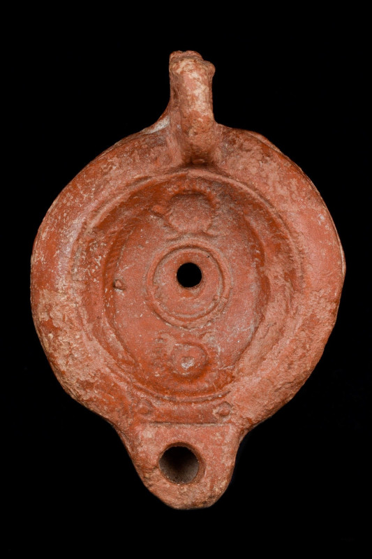 ROMAN OIL LAMP WITH LAUREL WREATHS
Ca. 100 - 200 AD. A mould-made redware terra...