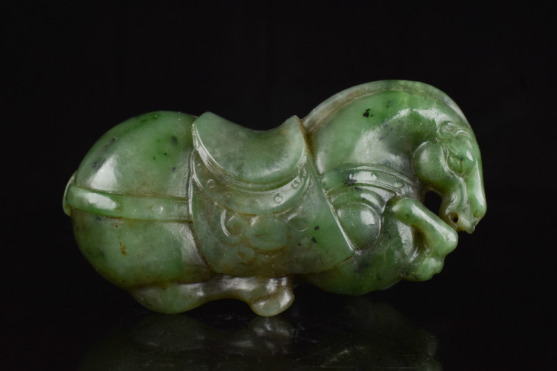 CHINESE QING DYNASTY JADE RECUMBENT HORSE
Ca. 19th century AD. A finely carved ...