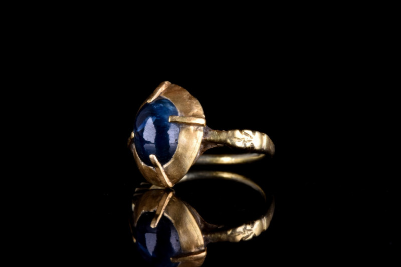 BRITISH MEDIEVAL GOLD RING WITH MASSIVE SAPPHIRE
Ca. 1600 AD. A gold thin band ...