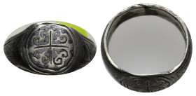 Silver ring with round bezel engraved with scrolling coma pattern and equal-armed cross to the centre. 10mm. 2.12 gr.