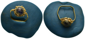 A gold ring with thin shank; bezel with rope pattern surrounding gem stone. 7mm. 2.1 gr.