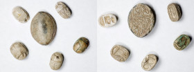 Group of Six Egyptian Glazed Steatite Scarabs. ca. 1550-924 B.C. Average Grade: FINE.
Comprising a blue-glazed cowroid with a cartouche set within a ...